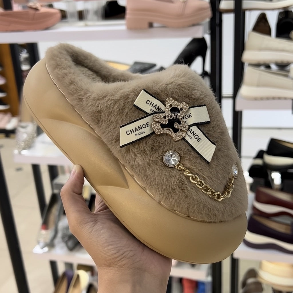 Beige slipper with decorative elements held by a hand, blurred shoe store background