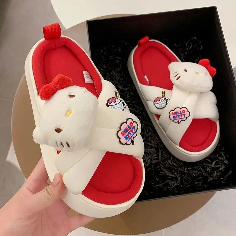A pair of red and white slippers with a cartoon character design, displayed inside a black box.