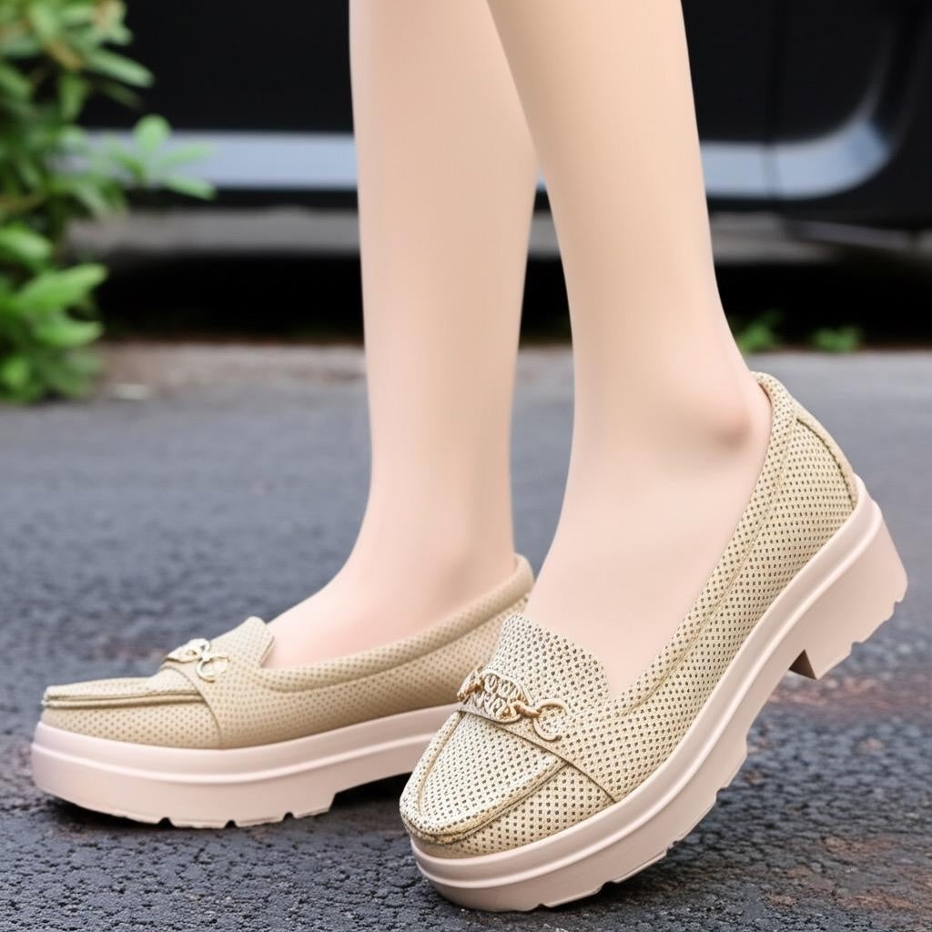 Beige loafers worn on feet with a blurred background