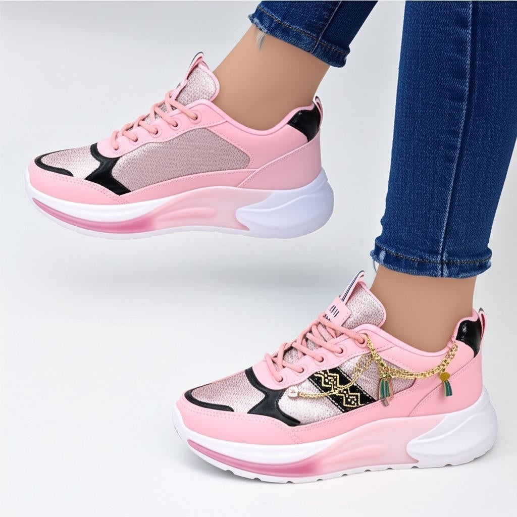 Pink and black sneakers with white soles worn by a person in blue jeans on a light gray background